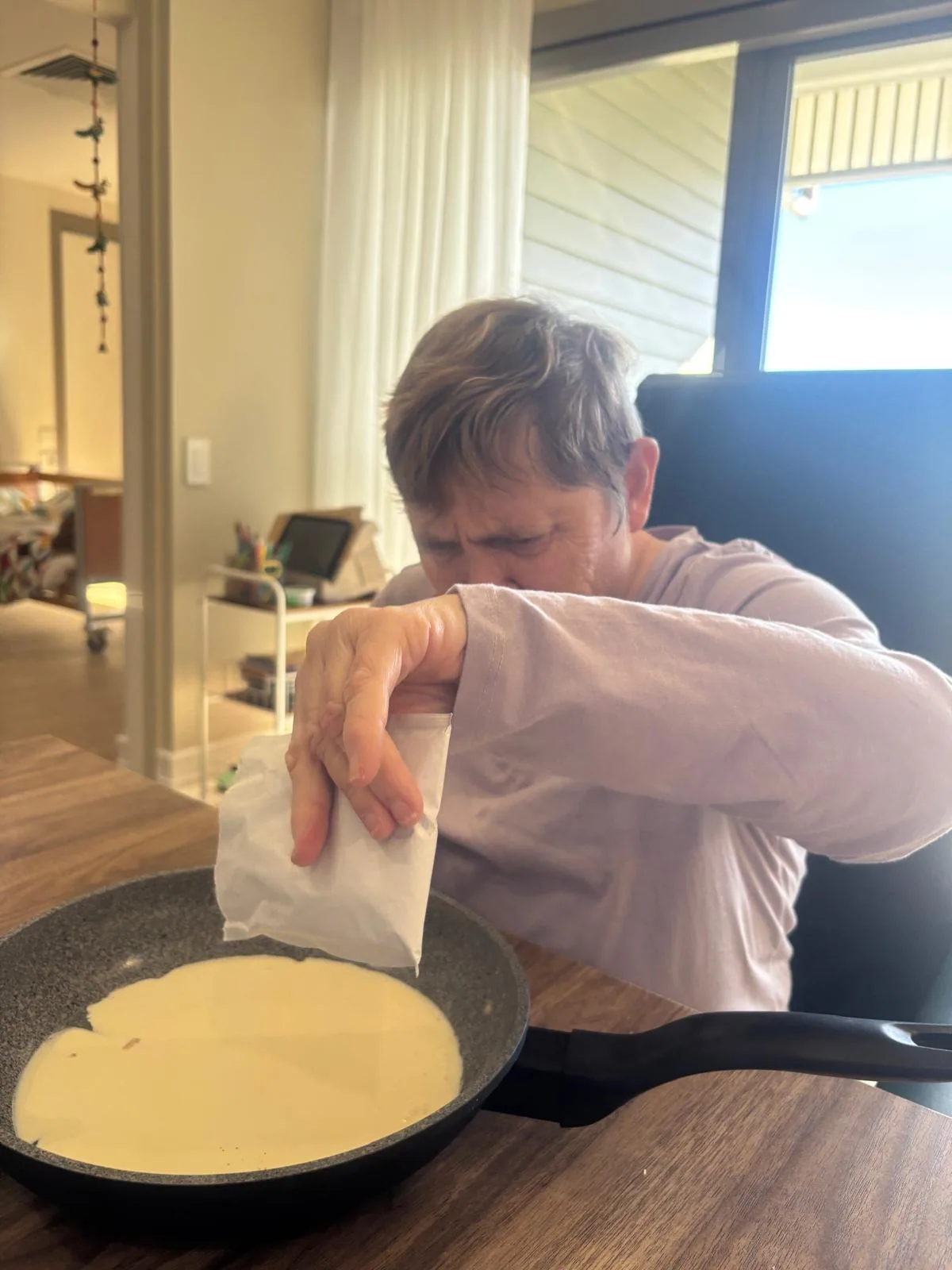 A participant pouring pancake batter into a pan