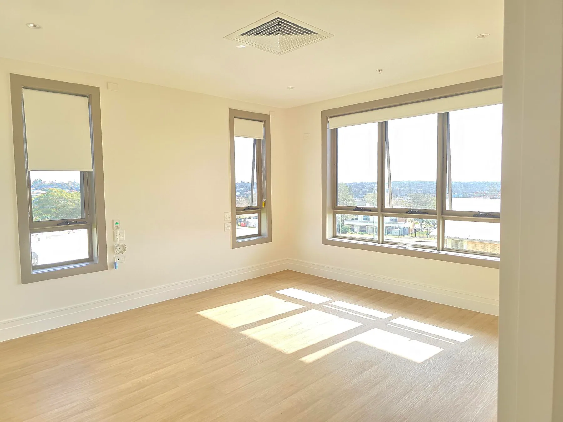 A one-bedroom SDA apartment bedroom with corner windows over the valley