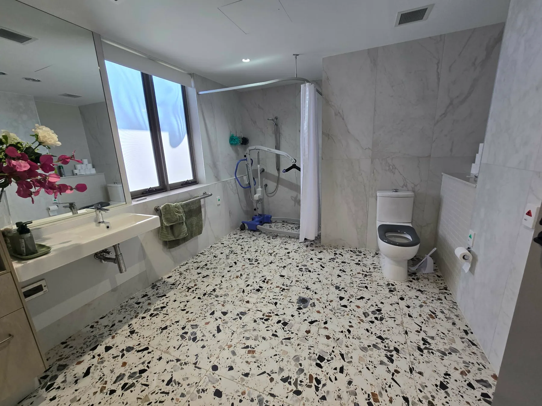 Fully accessible bathroom with roll-in shower and grab rails
